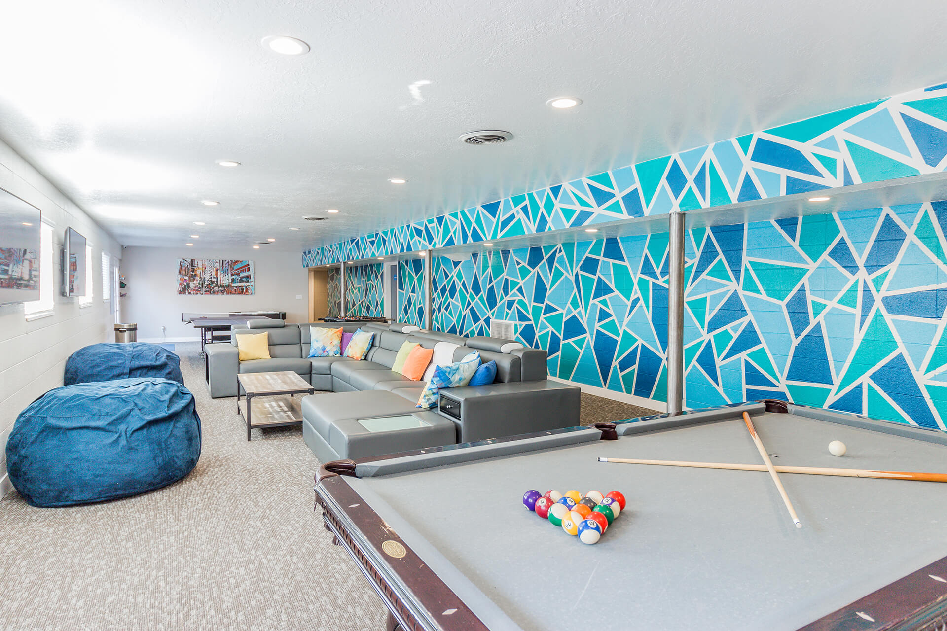 room with beanbag chairs, couches, and pool tables