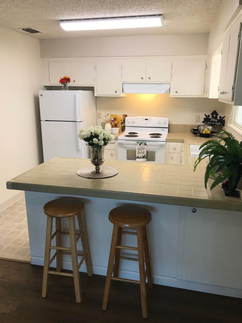 kitchen with fridge, stove, and barstools